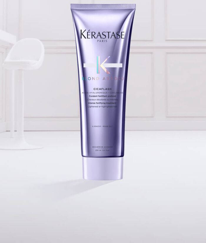 Un tubetto di prodotto per capelli Kerastase Blond Absole, con una consistenza cremosa e morbida di colore lilla che esce dal tappo.