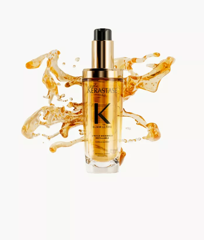 Siero per capelli Kerastase in una bottiglia trasparente con un'etichetta dorata, circondato da spruzzi d'olio dorato.