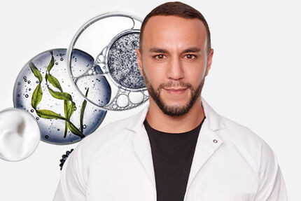 Un uomo in camice bianco sorridente, con elementi di laboratorio e ingredienti naturali sullo sfondo.