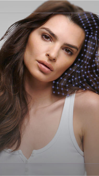 Immagine di una giovane donna con lunghi capelli scuri, che indossa una canotta bianca, con uno sfondo sfumato.