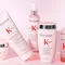 A collection of Kerastase Genesis hair care products displayed on a light pink background, including a shampoo, conditioner, serum, and a restorative mask, all featuring the brand's logo.