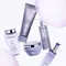 A collection of Kerastase hair care products displayed elegantly on a iridescent background. The products include a shampoo, conditioner, a treatment, and a serum, all presented in sleek packaging with a lavender theme.