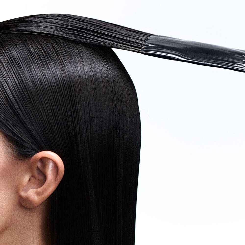 Capelli scuri lisci con applicazione di prodotto.