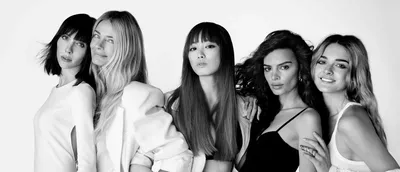 A black-and-white portrait of five women standing side by side, each showcasing different hairstyles and outfits, exuding confidence and elegance.