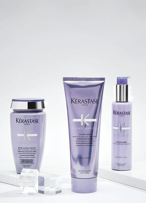 Immagine di vari prodotti per la cura dei capelli del marchio Kerastase, disposti su uno sfondo blu.