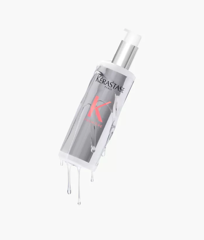Flacone di siero per capelli Kerastase con gocce d'acqua che scivolano lungo la superficie.