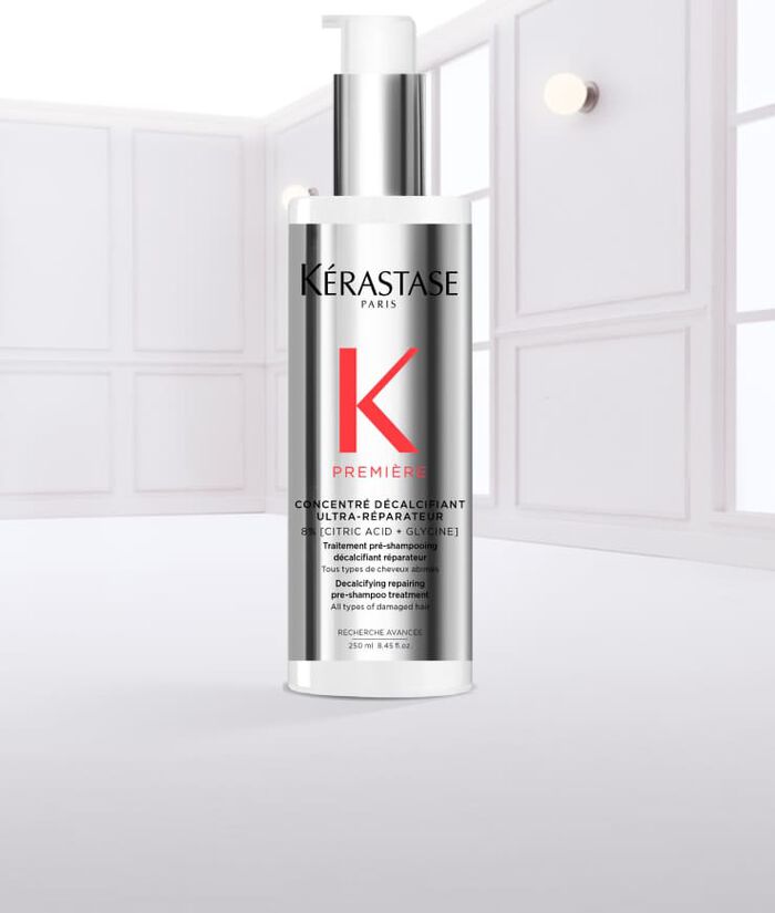 Flacone di siero per capelli Kerastase con gocce d'acqua che scivolano lungo la superficie.