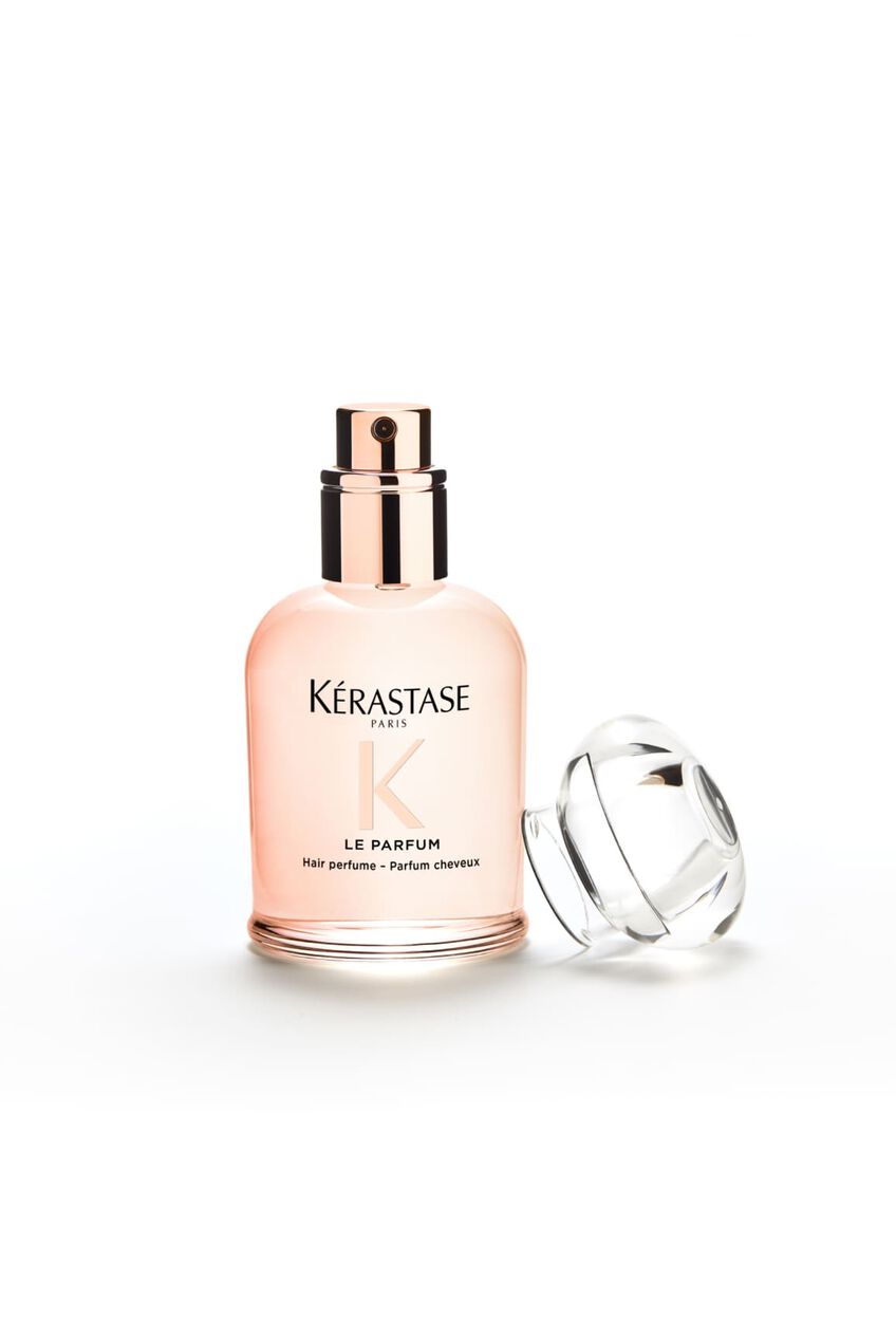 Flacone del profumo Gloss Absolu, il suo tappo e appoggiato accanto ad esso