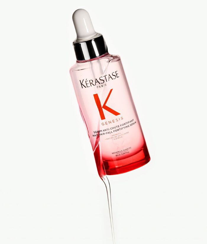 Siero per capelli Kerastase Genesis, in bottiglia trasparente con contagocce, su sfondo chiaro.