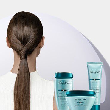 Donna con coda di cavallo lucida e prodotti Kerastase Resistance turchesi.