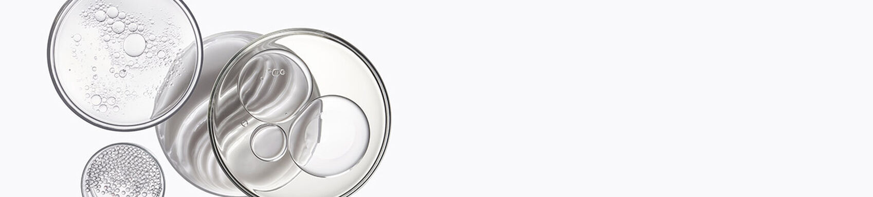 Contenitori di vetro con liquidi trasparenti, bolle e sfere.
