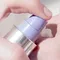 Close-up image of a hand pressing a pump bottle to dispense a creamy product.
