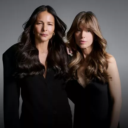Due donne di generazioni diverse vestite di nero, a illustrazione delle abitudini per mantenere capelli sani nel tempo