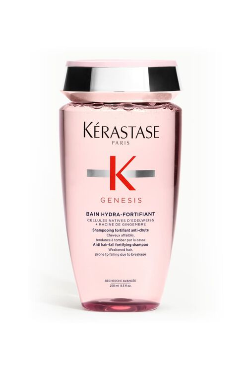 Bottiglia trasparente rosa dello shampoo Kerastase Genesis Bain Hydra-Fortifiant per capelli indeboliti, inclinata.