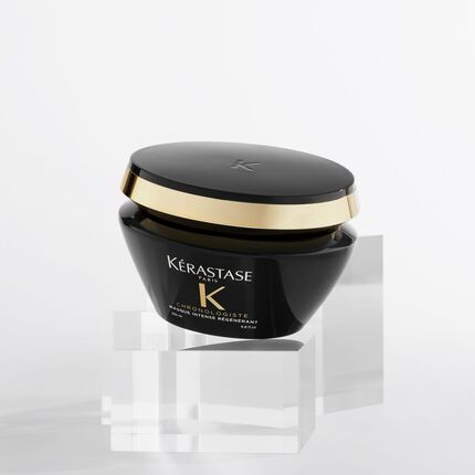 Vaso di crema Kerastase Chronologiste su supporti trasparenti, con un tappo dorato.