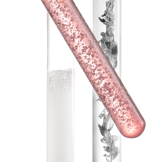 A close-up of three test tubes: one contains a clear liquid, another has a pink liquid with bubbles, and the third shows swirling gray smoke in a clear solution.