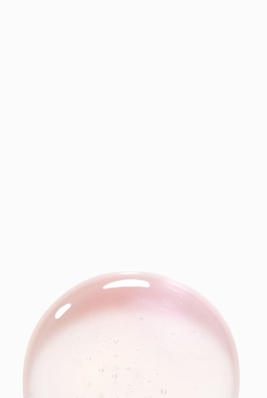 Una bolla traslucida con riflessi rosa e blu, gallegiante su uno sfondo bianco.