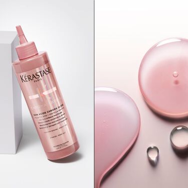 Il fondant soin acide chroma gloss Kerastase e posizionato in piedi su una base trasparente.