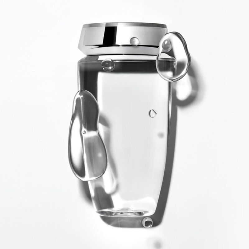 Un contenitore trasparente per acqua appeso a una superficie bianca, con dettagli metallici.