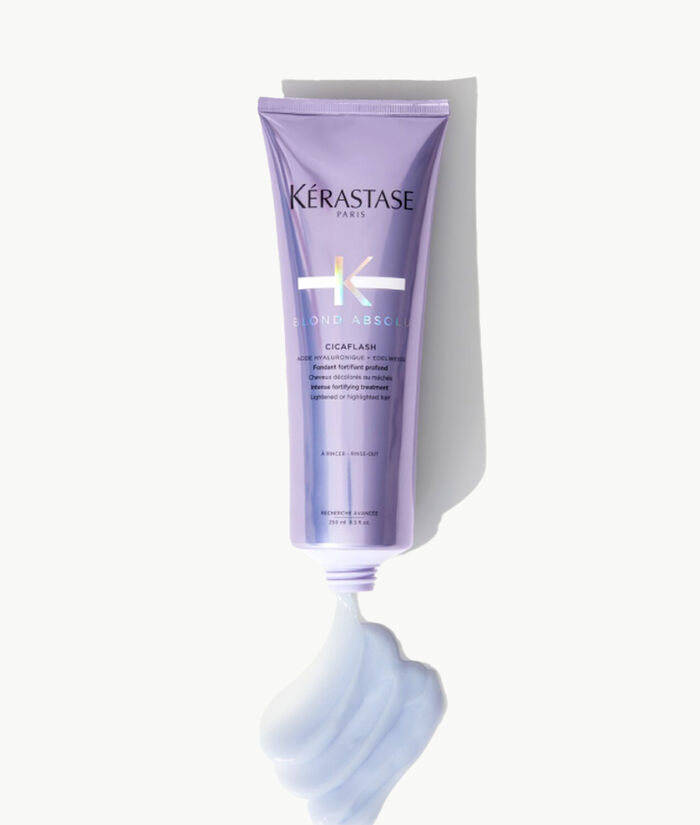 Un tubetto di prodotto per capelli Kerastase Blond Absole, con una consistenza cremosa e morbida di colore lilla che esce dal tappo.