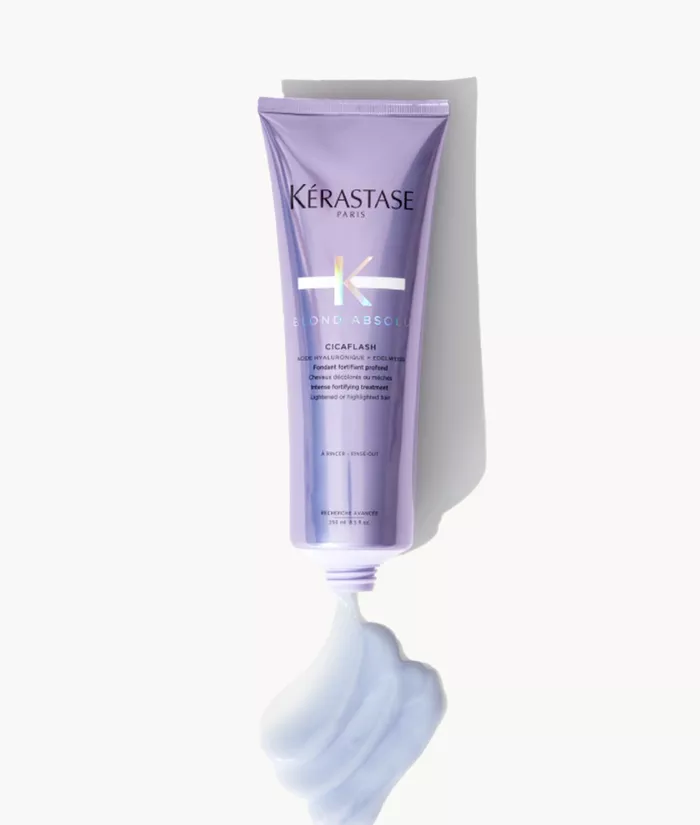 Un tubetto di prodotto per capelli Kerastase Blond Absole, con una consistenza cremosa e morbida di colore lilla che esce dal tappo.