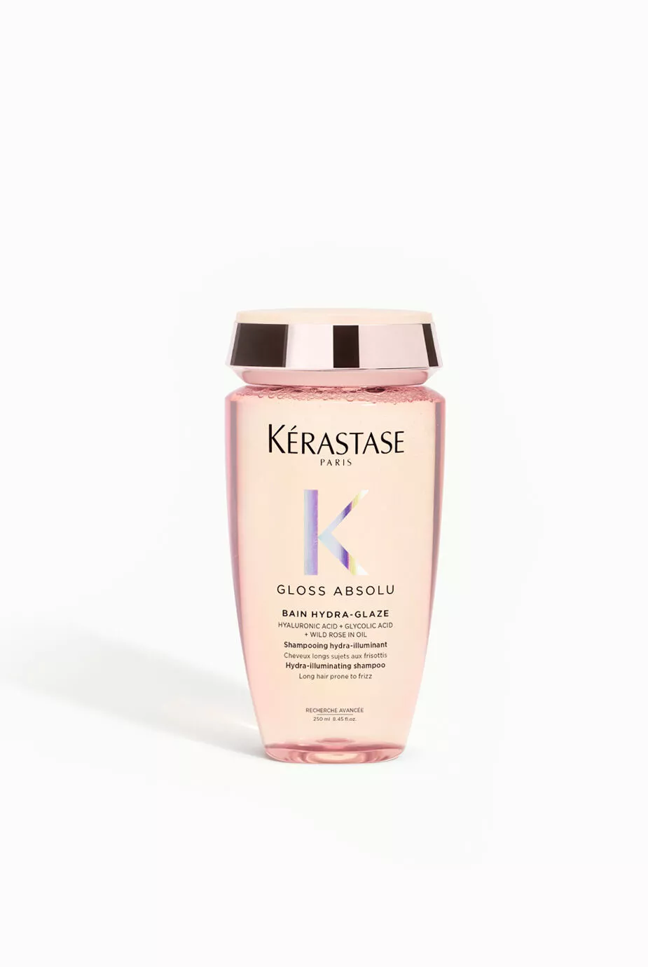 A bottle of Kerastase Gloss Absolu Bain Hydra-Glaze, a pink shampoo designed for hydrating and enhancing shine, with a gold lid and label featuring the brand's logo.