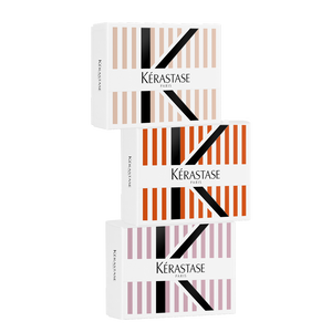 Three elegantly designed boxes of Kerastase hair products, stacked vertically, featuring a striped pattern in various colors.