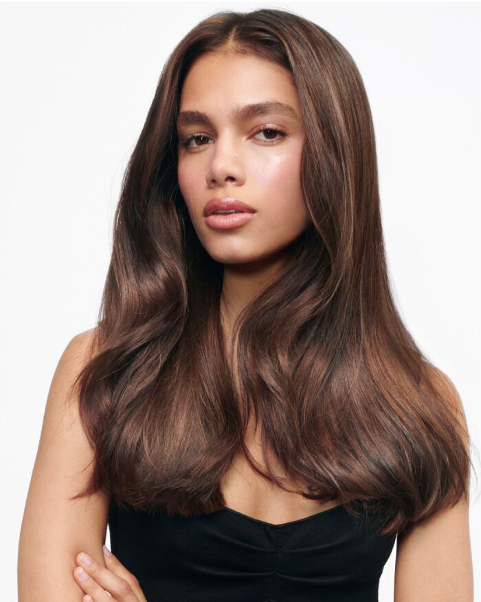 Ritratto di una giovane donna con lunghi capelli castani fluenti, che indossa una maglietta nera e ha un'espressione serena.