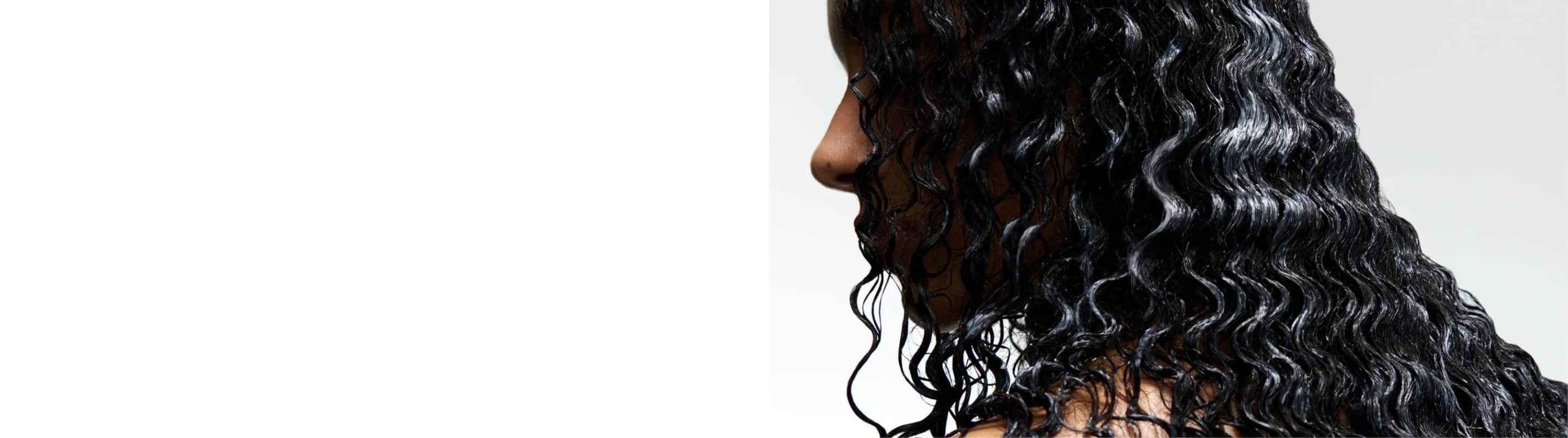 Donna che usa prodotti Kérastase sui capelli bagnati