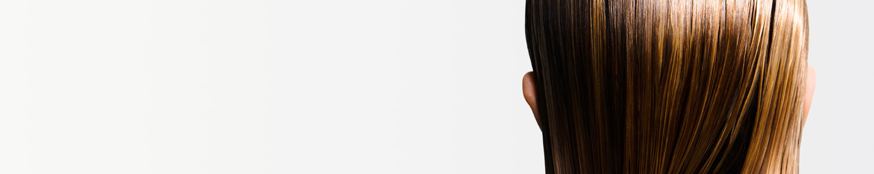 Donna che usa prodotti Kérastase sui capelli bagnati