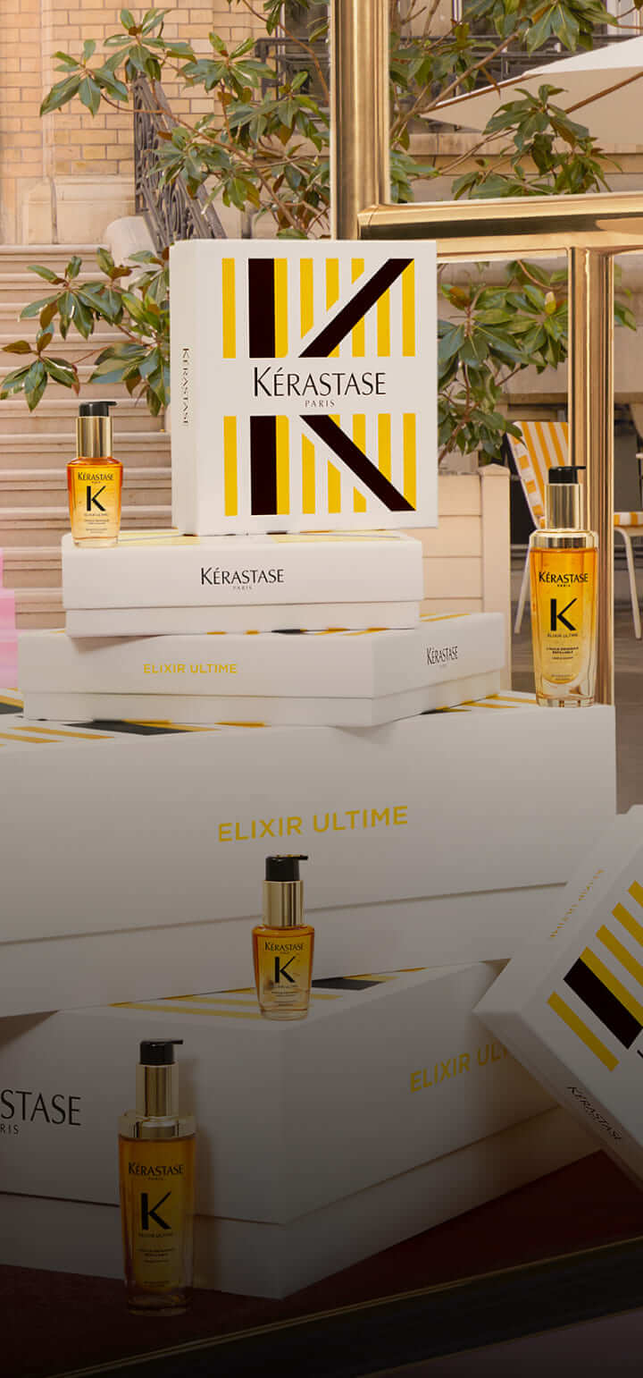 Scatole eleganti di prodotti Kérastase Elixir Ultime con diverse bottiglie in un ambiente raffinato.