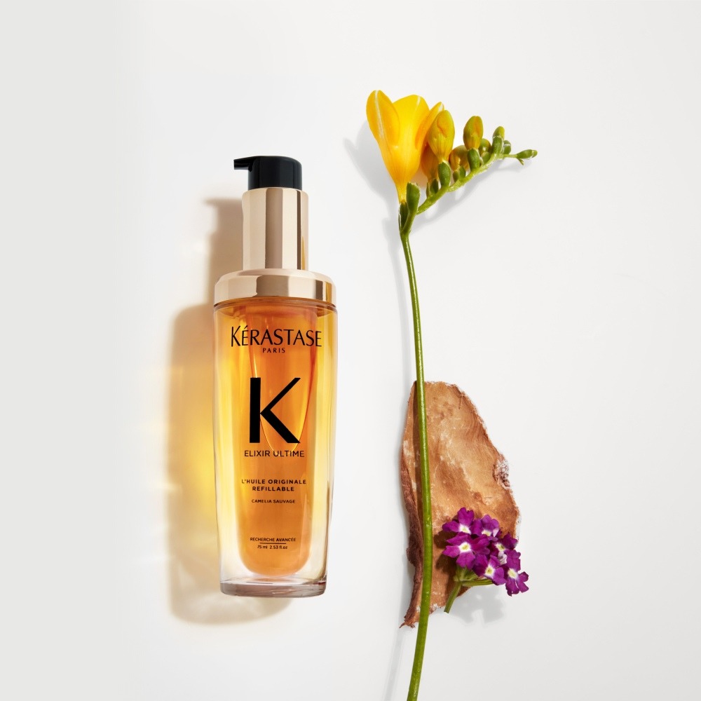 Il nuovo Elixir Ultime ricaricabile si presenta su uno sfondo grigio puro con fiori di fresia, eliotropio e legno di sandalo.