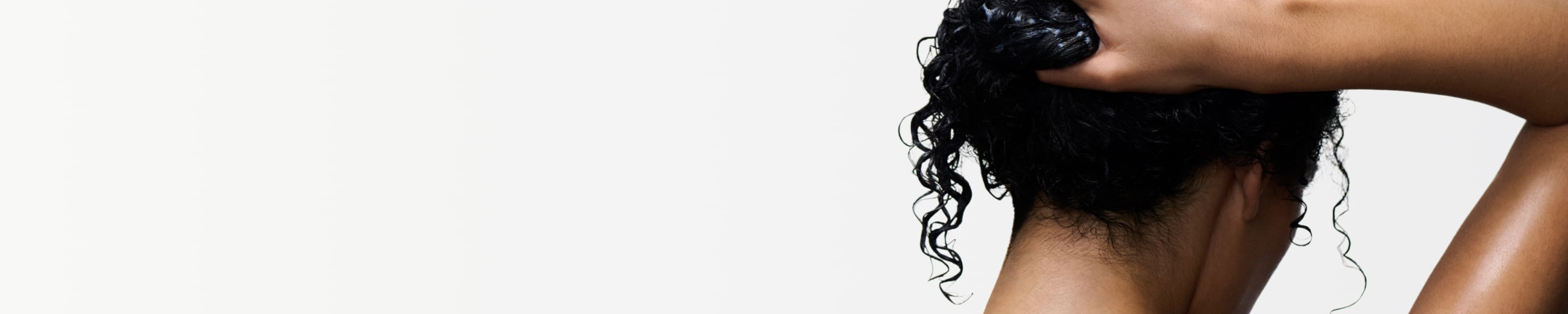 Donna che usa prodotti Kérastase sui capelli bagnati