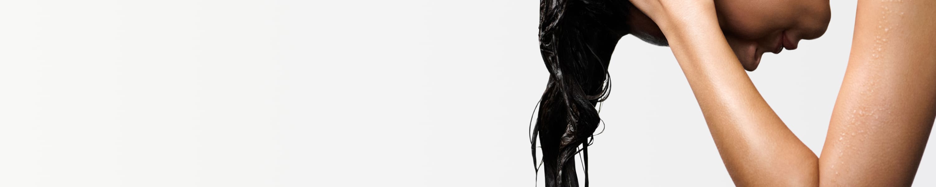 Donna che usa prodotti Kérastase sui capelli bagnati